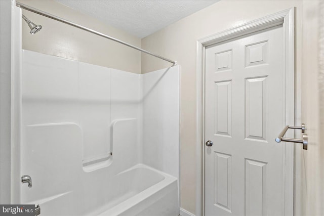 bathroom featuring shower / bath combination and a textured ceiling