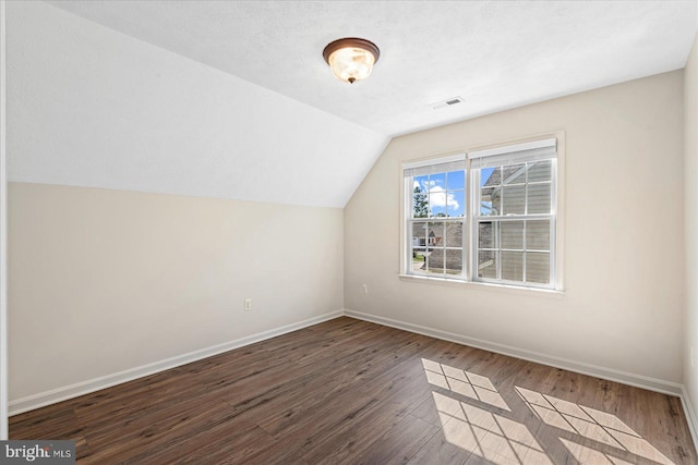 bonus room featuring vaulted ceiling and dark hardwood / wood-style floors