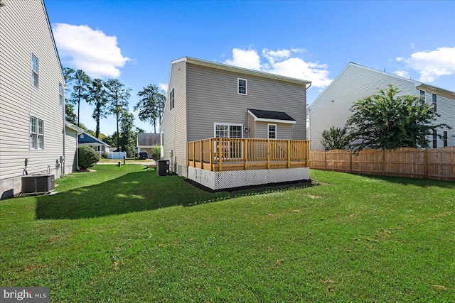 back of house featuring a lawn, a wooden deck, and central AC