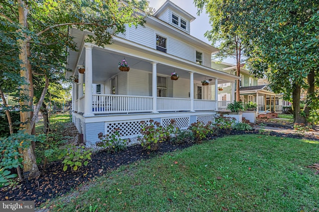 farmhouse inspired home with a front yard, covered porch, and ceiling fan