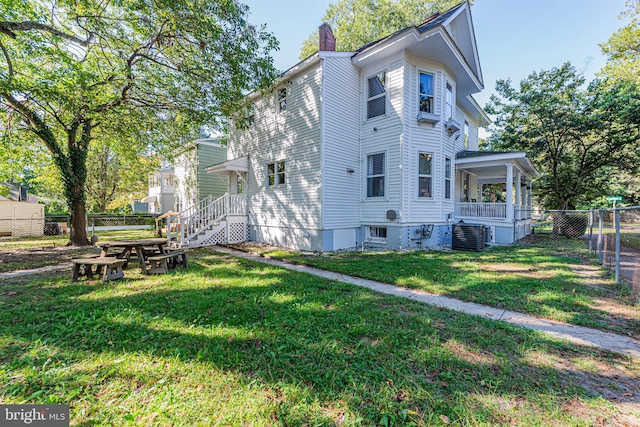 view of side of home featuring a lawn and central AC