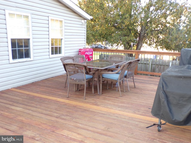 wooden terrace with outdoor dining area and area for grilling