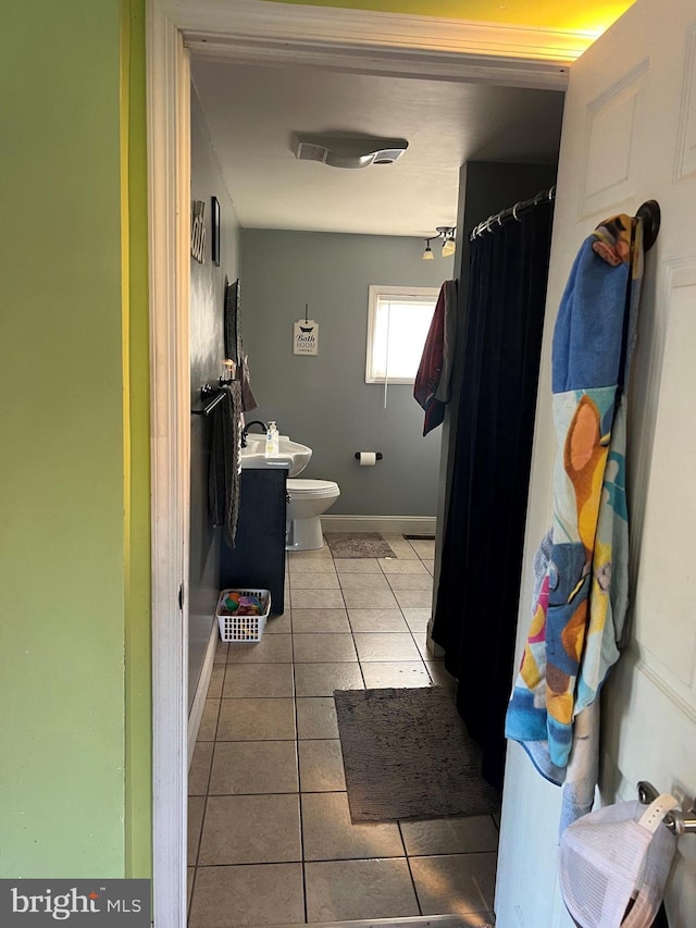 bathroom featuring toilet and tile patterned flooring