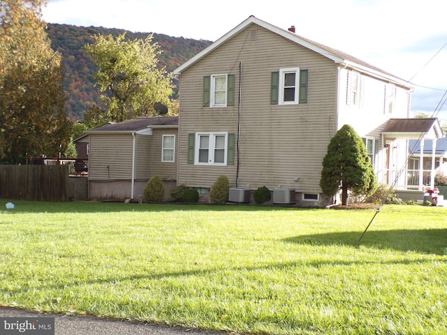 view of side of home featuring a yard and cooling unit