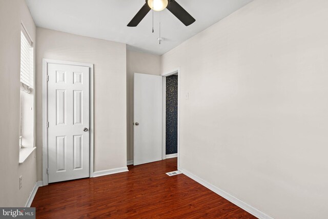 unfurnished bedroom featuring ceiling fan and dark hardwood / wood-style flooring