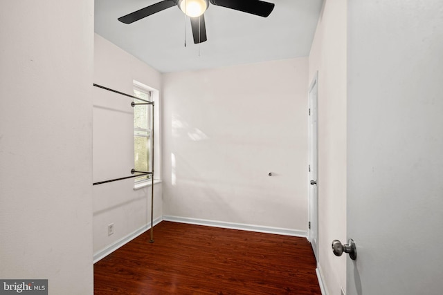 empty room with ceiling fan and dark wood-type flooring