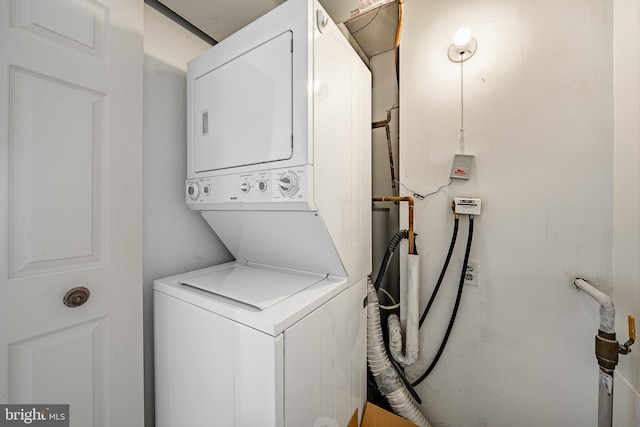 clothes washing area with stacked washing maching and dryer