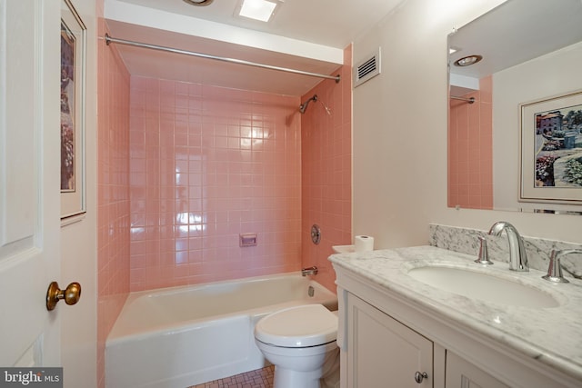 full bathroom with toilet, tiled shower / bath combo, vanity, and tile patterned floors