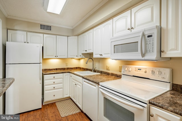 kitchen with dark hardwood / wood-style flooring, white cabinetry, crown molding, sink, and white appliances