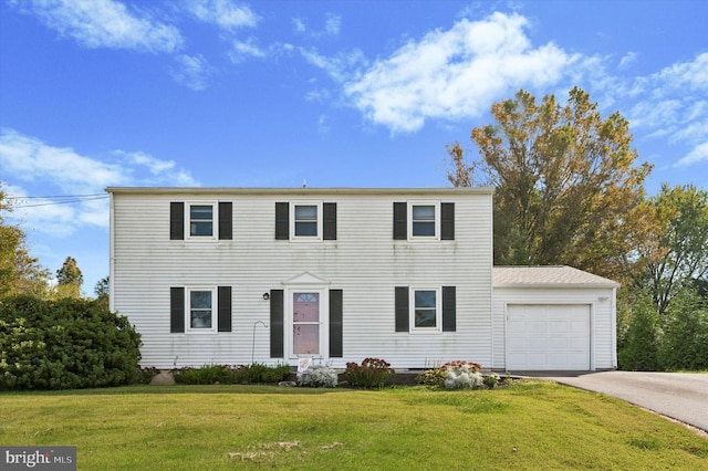 colonial house with a garage and a front lawn