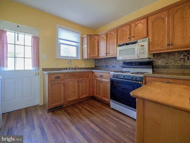 kitchen featuring dark hardwood / wood-style flooring, tasteful backsplash, sink, and white appliances