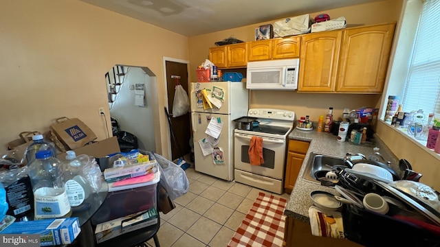 kitchen featuring white appliances, sink, and light tile patterned floors