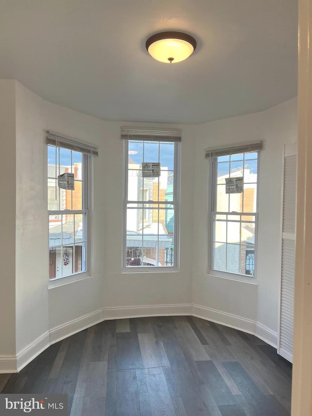 empty room with dark hardwood / wood-style flooring