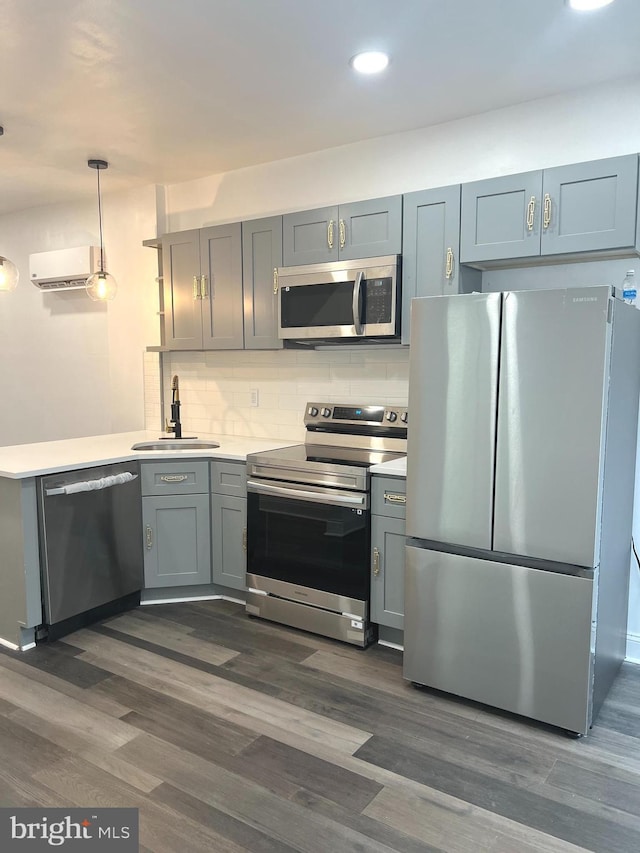 kitchen featuring a wall mounted air conditioner, dark hardwood / wood-style flooring, backsplash, stainless steel appliances, and sink