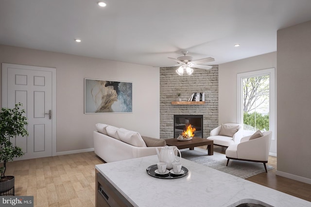 living room featuring a fireplace, hardwood / wood-style flooring, and ceiling fan