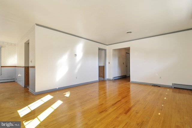 empty room featuring a baseboard radiator and light wood-type flooring