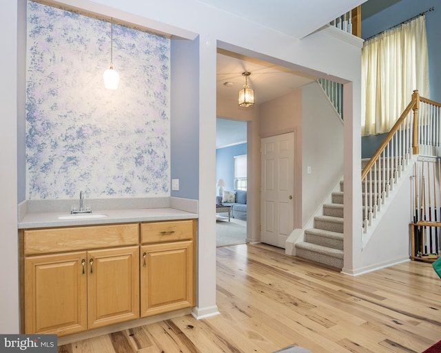 kitchen featuring hanging light fixtures, sink, and light hardwood / wood-style floors