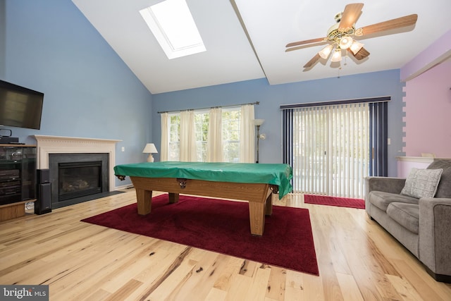 recreation room featuring light wood-type flooring, high vaulted ceiling, ceiling fan, a skylight, and pool table