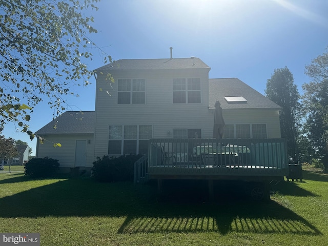 back of property with a yard and a wooden deck