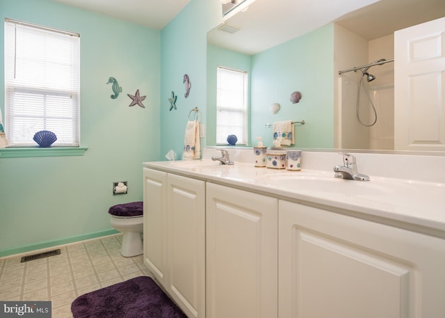 bathroom with walk in shower, vanity, and toilet