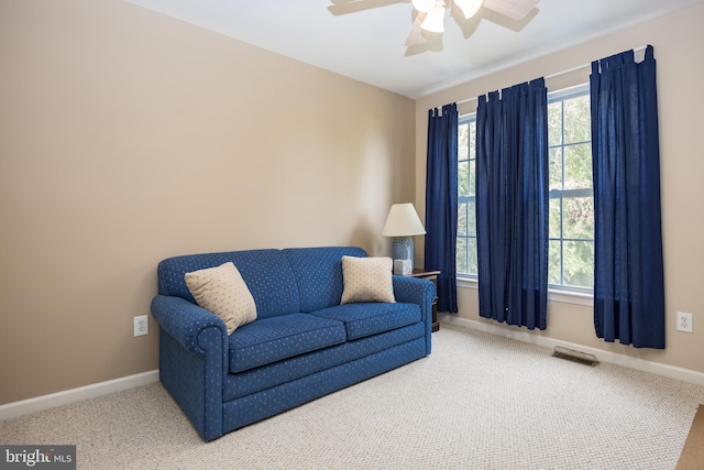 living area featuring carpet floors and ceiling fan