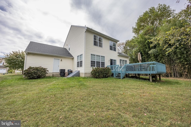 rear view of house featuring a deck and a yard