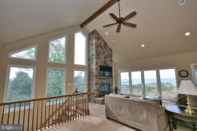 living room with high vaulted ceiling, beamed ceiling, and a healthy amount of sunlight