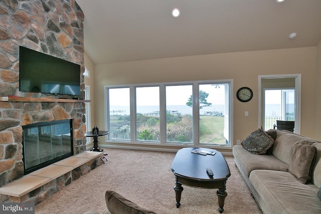 living room with carpet floors, lofted ceiling, and a stone fireplace