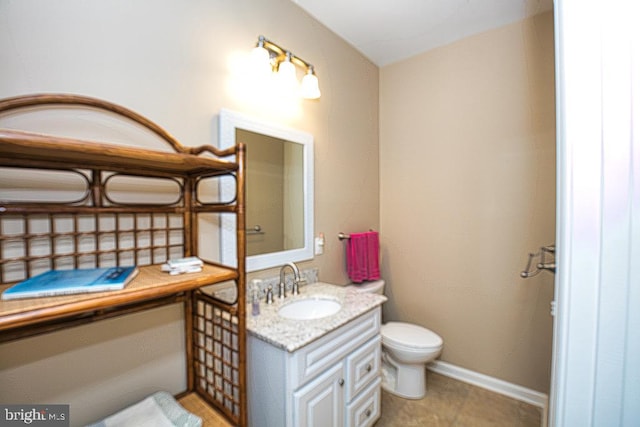 bathroom with tile patterned flooring, vanity, and toilet