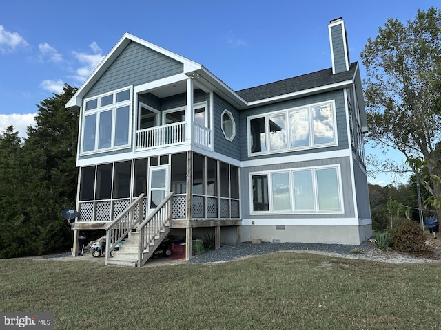 back of house with a balcony, a sunroom, and a lawn