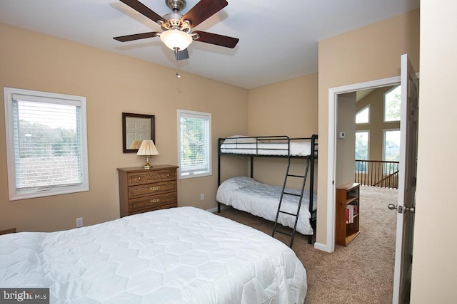 carpeted bedroom featuring multiple windows and ceiling fan