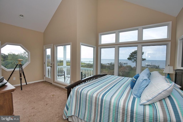 carpeted bedroom with a water view, access to outside, and high vaulted ceiling