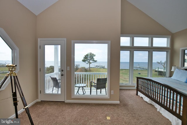 bedroom featuring a water view, multiple windows, and high vaulted ceiling