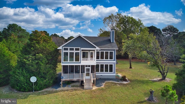 rear view of property with a sunroom and a yard