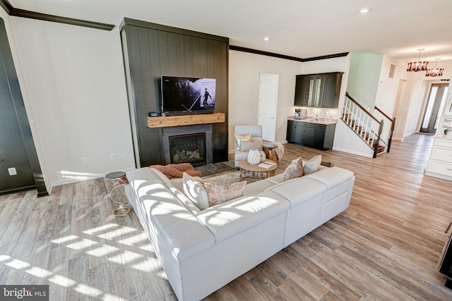 living room featuring crown molding and light hardwood / wood-style floors