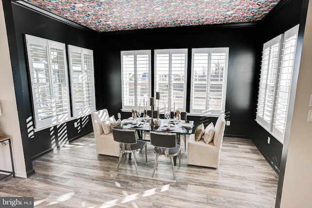 dining space with ornamental molding and light wood-type flooring