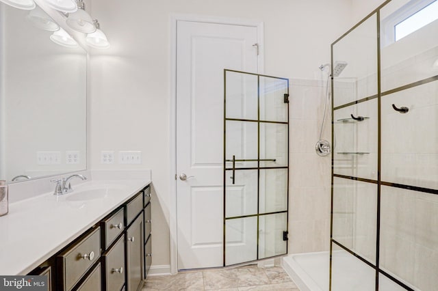 bathroom featuring a shower with door and vanity