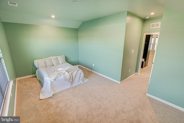 bedroom with vaulted ceiling and light colored carpet