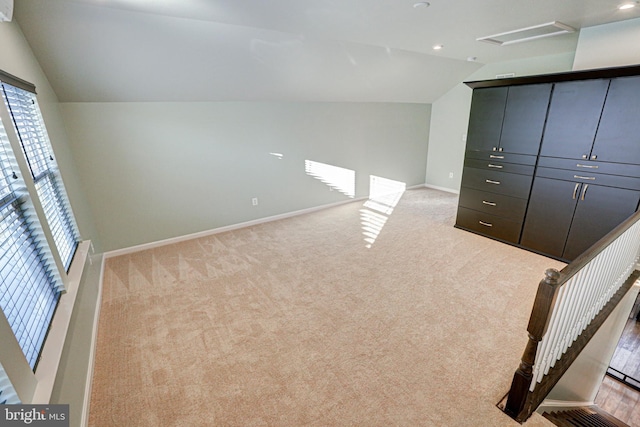 additional living space with lofted ceiling and light colored carpet