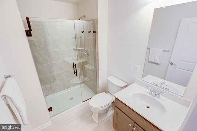 bathroom with a shower with door, vanity, and toilet