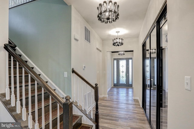 entryway featuring wood-type flooring and an inviting chandelier