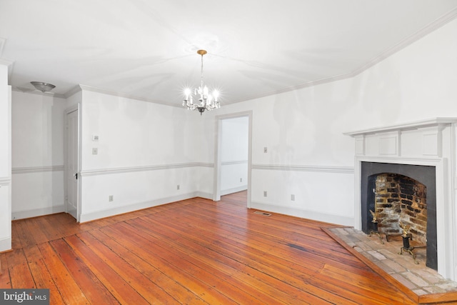 unfurnished living room featuring wood-type flooring, ornamental molding, and a notable chandelier