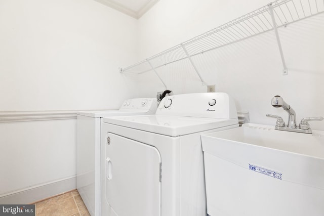 washroom with separate washer and dryer, ornamental molding, sink, and light tile patterned floors