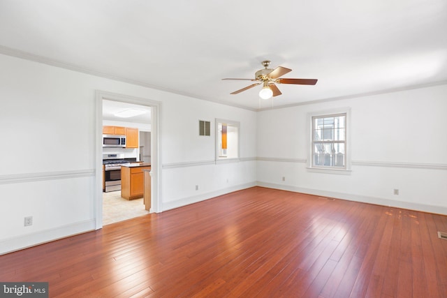 empty room with light hardwood / wood-style floors, ornamental molding, and ceiling fan