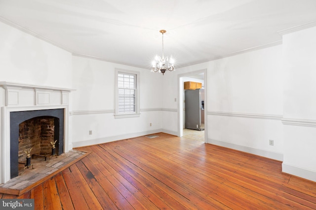 unfurnished living room with light hardwood / wood-style flooring, a chandelier, and ornamental molding