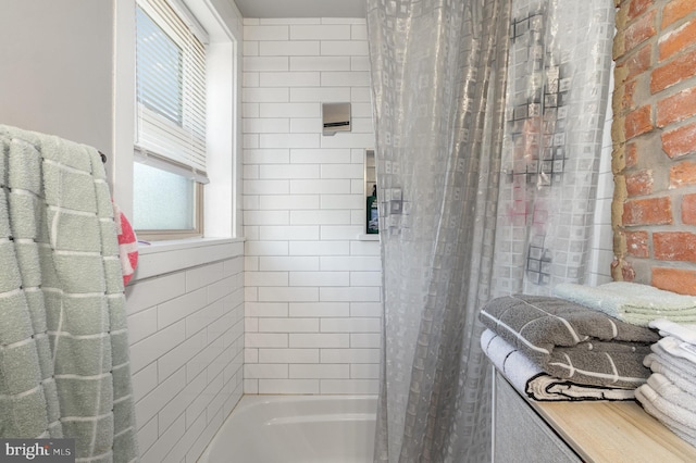 bathroom with shower / bath combination with curtain and brick wall