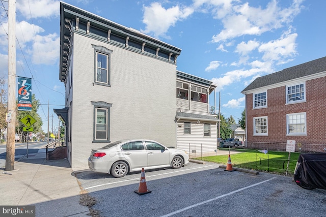 exterior space featuring a balcony and a front lawn