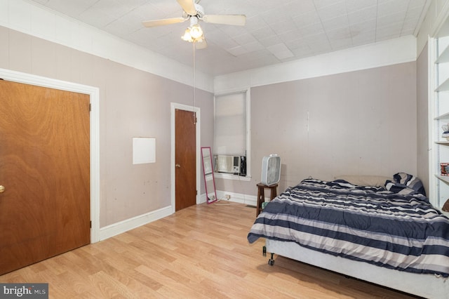 bedroom with ceiling fan, cooling unit, crown molding, and light hardwood / wood-style floors