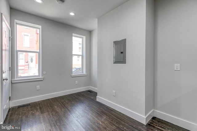 unfurnished room featuring dark wood-type flooring and electric panel