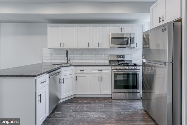 kitchen with white cabinets, appliances with stainless steel finishes, sink, and dark hardwood / wood-style flooring